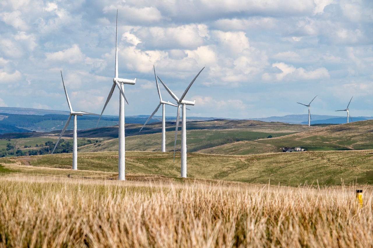 wind turbines in a field at sunset with energy efficiency data overlay